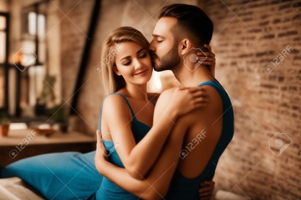 Profile side view portrait of nice charming attractive gorgeous stunning lovely lovable lady cuddling masculine macho guy harmony idyllic affair in loft brick industrial style interior room house