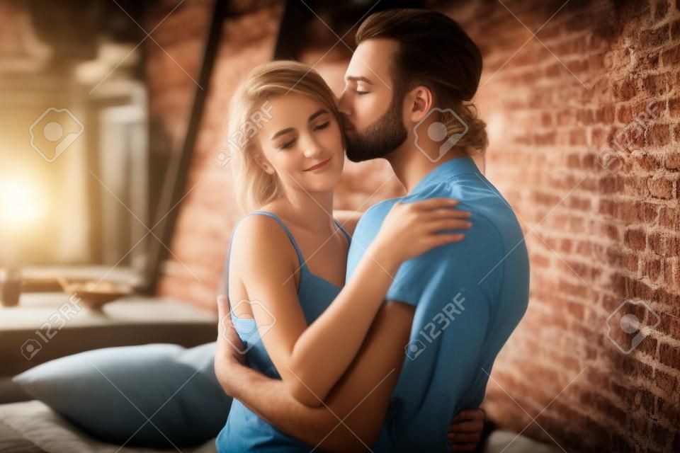 Profile side view portrait of nice charming attractive gorgeous stunning lovely lovable lady cuddling masculine macho guy harmony idyllic affair in loft brick industrial style interior room house