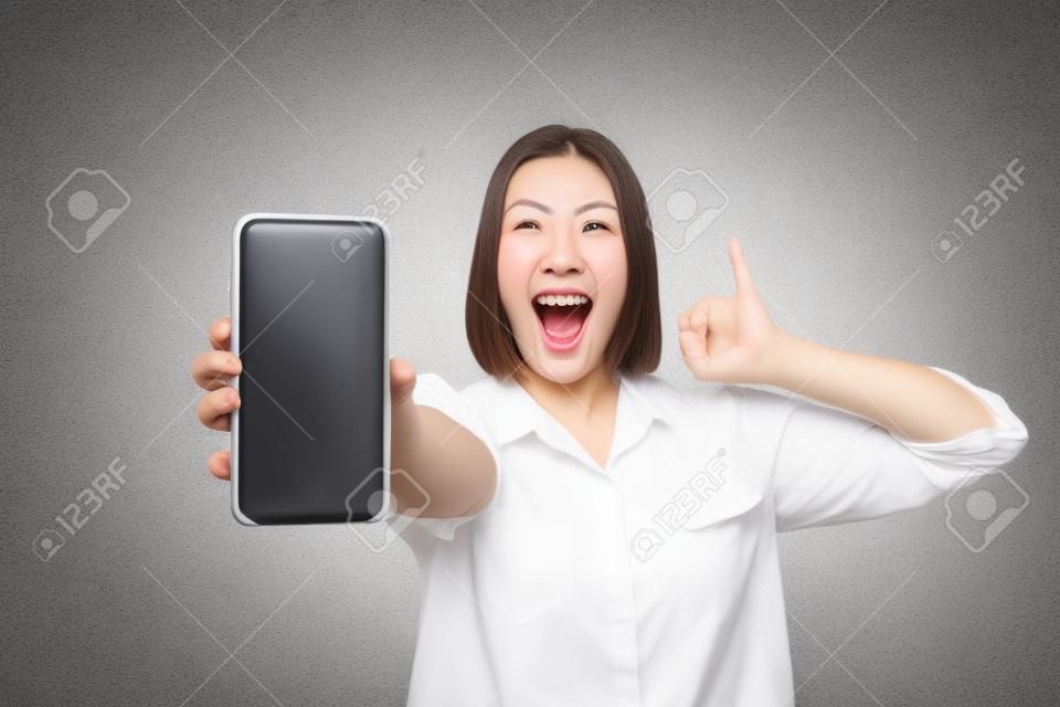 写真クレイジー美しい彼女の女性の腕の腕電話は親指を上げる叫び声を上げる顧客購入者デバイス低価格のカジュアルな白いシャツを着てカジュアルな白いシャツ孤立した灰色の背景
