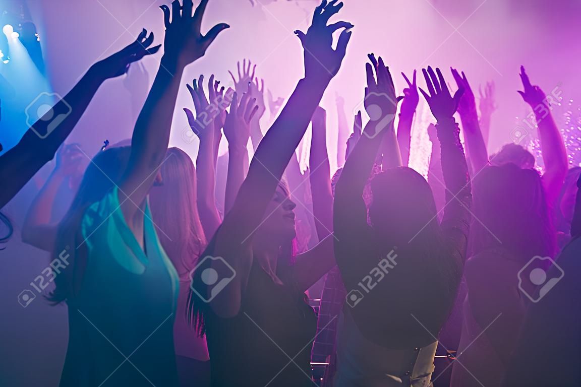 La photo en gros plan de nombreuses personnes fête d'anniversaire danse matraque lumières violettes confettis brouillard discothèque mains soulevées vêtements de cérémonie brillants