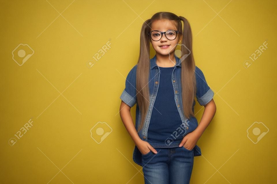 Close-up foto van kleine dame armen zakken blij terug klasse dragen specs geruit shirt jeans denim geïsoleerde gele achtergrond