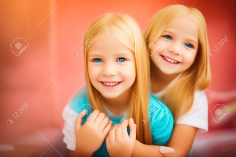 Close up photo of charming children blonde brunette hair have bonding feel satisfied sit bed indoors room have sleepover