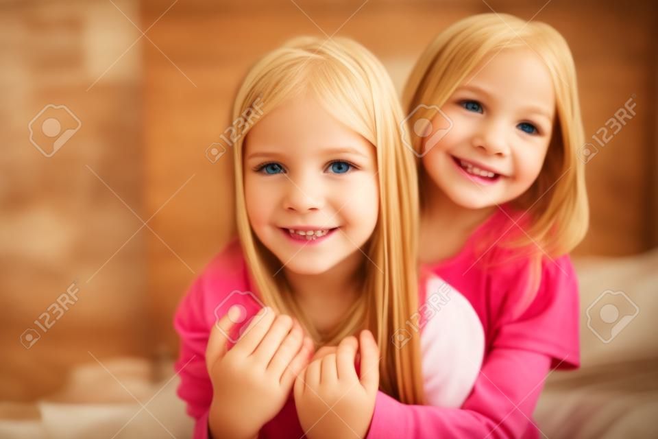 Close up foto de crianças encantadoras loira morena cabelo ter colagem sentir satisfeito sentar cama dentro de casa quarto ter sleepover