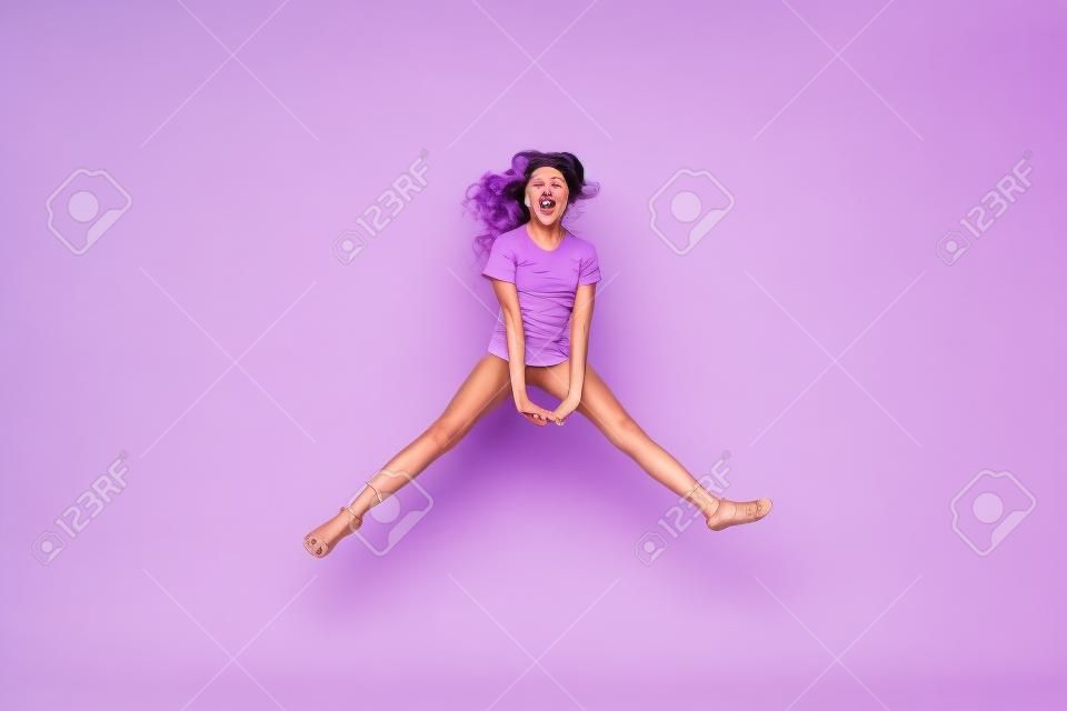 라일락 보라색 보라색 파스텔 색상 배경에서 고립되어 즐겁게 뛰어다니는 그녀의 전체 길이 신체 크기 보기