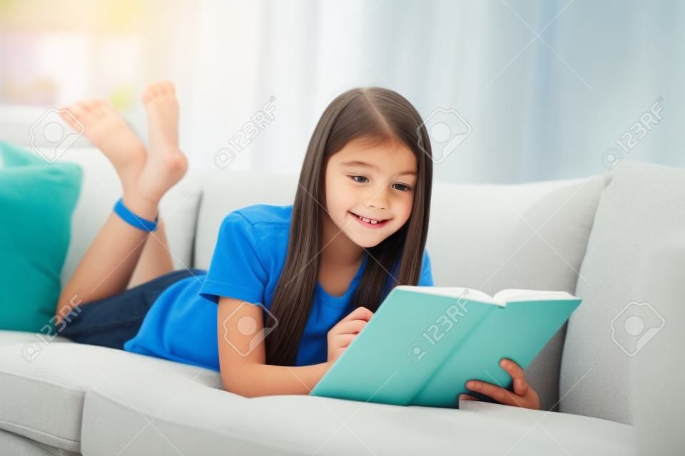 小さなかわいい生徒の学校の女性は、快適なソファ読み日記本肯定的な良い気分勤勉な学生がメモ鉛筆社会的距離検疫ホームスタディ快適室屋内で横たわっている