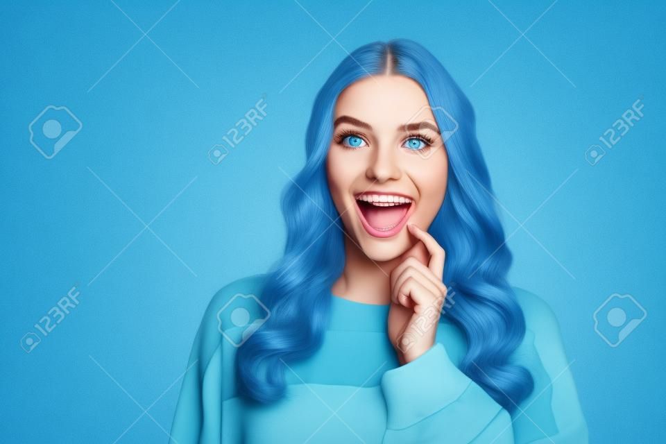 Portrait of attractive cheerful curious wavy-haired girl looking aside copy space isolated over bright blue color background