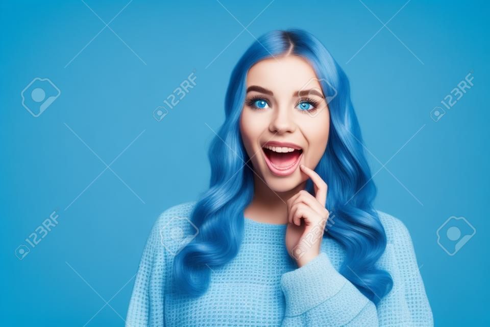 Portrait of attractive cheerful curious wavy-haired girl looking aside copy space isolated over bright blue color background