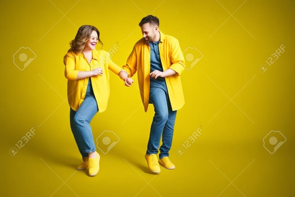 Zdjęcie słodkiej, uroczej żony męża nosi koszule dżinsowe tańczące puste miejsce na białym tle koloru żółtego