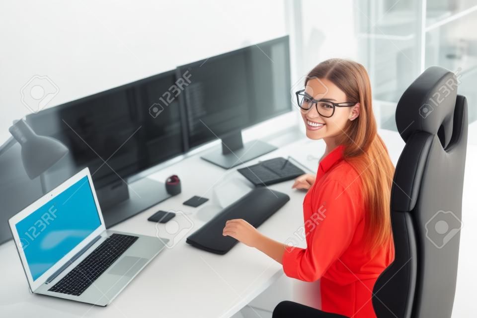 Profilo vista laterale ritratto di attraente ragazza allegra geek che fornisce servizi di sicurezza informatica presso la postazione di lavoro sul posto di lavoro al chiuso