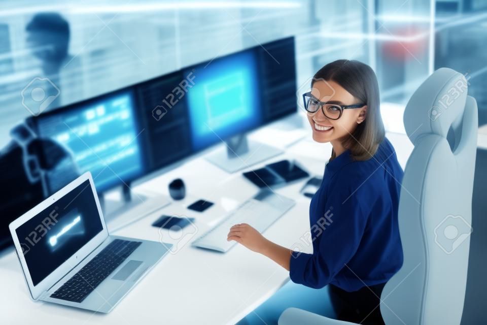 Profilo vista laterale ritratto di attraente ragazza allegra geek che fornisce servizi di sicurezza informatica presso la postazione di lavoro sul posto di lavoro al chiuso