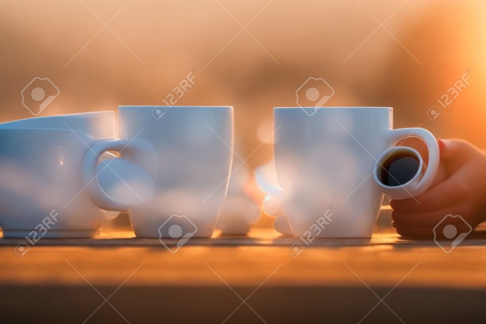 couple with two cups of morning coffee on sunrise light