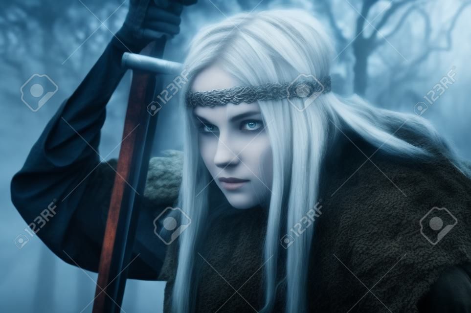 Viking girl with sword in a fog wood