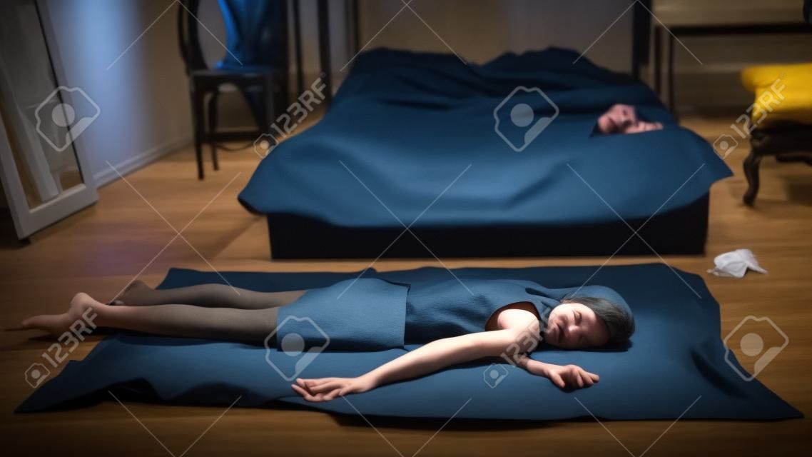 Crime scene simulation. Strangled victim lying on the floor in a luxury bedroom