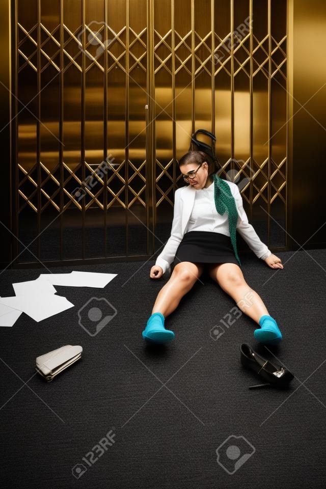 Crime scene. Business woman strangled by scarf in old elevator
