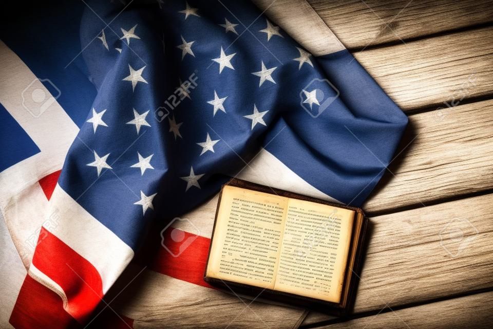 Gealterte USA-Flagge und Buch. Buch neben Nationalflagge zu legen. Gesetz schützt Sie. Wir vertrauen in Gott.