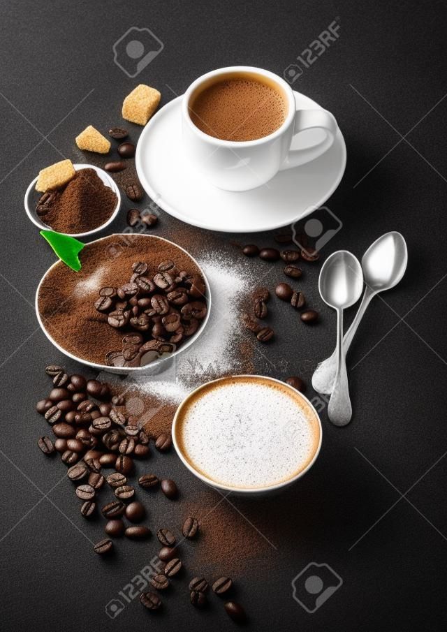 Biały kubek świeżej surowej kawy ekologicznej z fasolą i mielonym proszkiem z kostkami cukru trzcinowego z liśćmi drzewa kawowego na ciemnym tle. Widok z góry