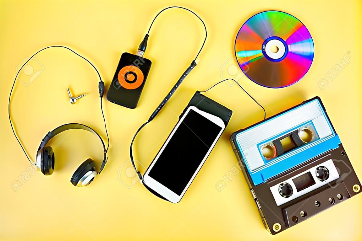 The concept of the evolution of music. Cassette, CD-disk, mp3 player, mobile phone. Vintage and modernity. Music support