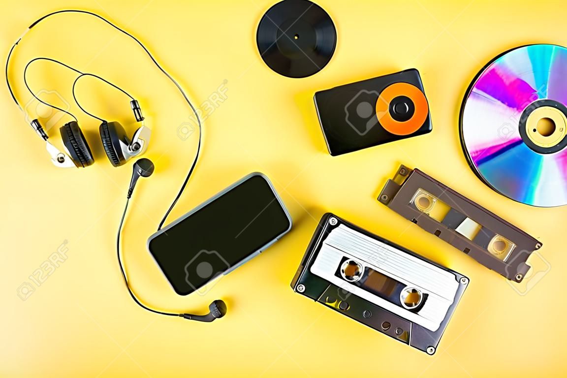 The concept of the evolution of music. Cassette, CD-disk, mp3 player, mobile phone. Vintage and modernity. Music support