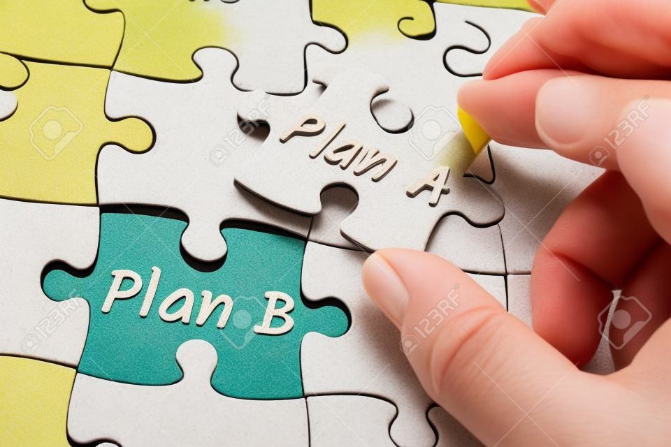 Plan A y Plan B en un rompecabezas de pieza faltante, dos dedos sosteniendo el plan A de la pieza