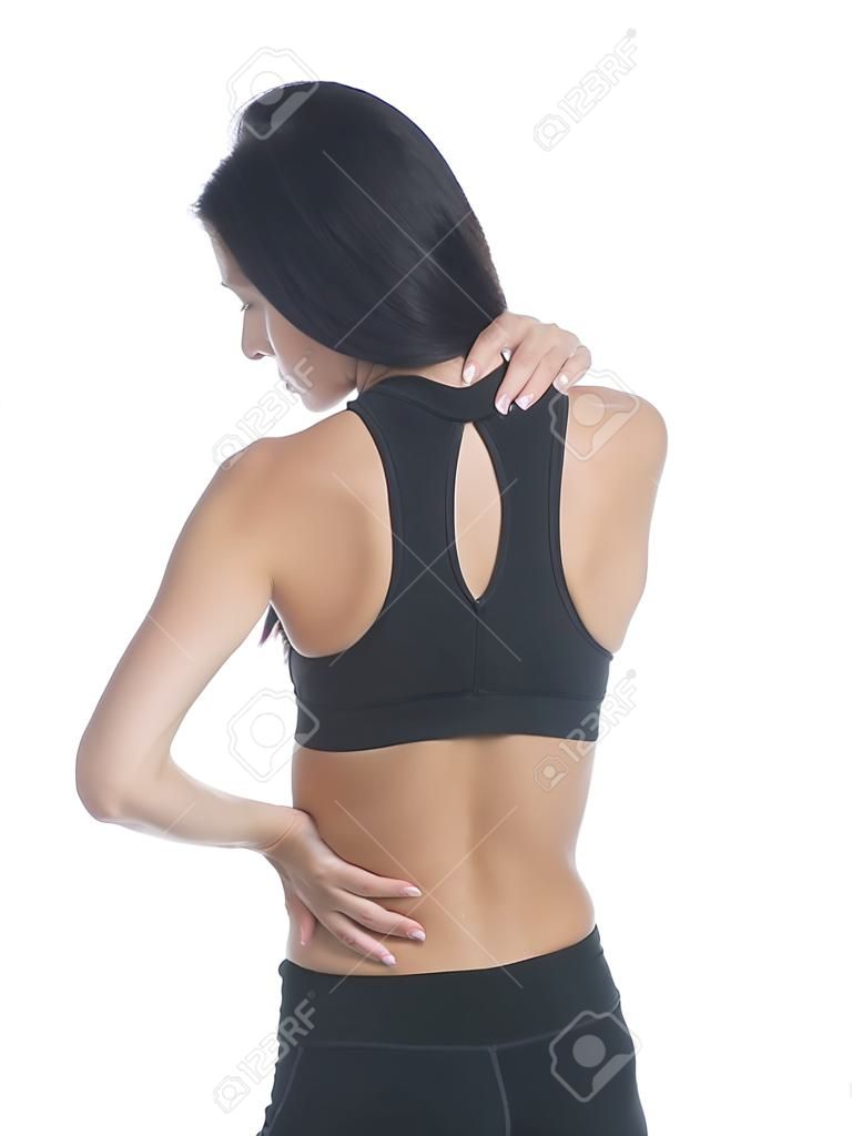 Aislado disparo de estudio de una mujer en un traje de fitness experimentan dolor de espalda, cuello y hombro.