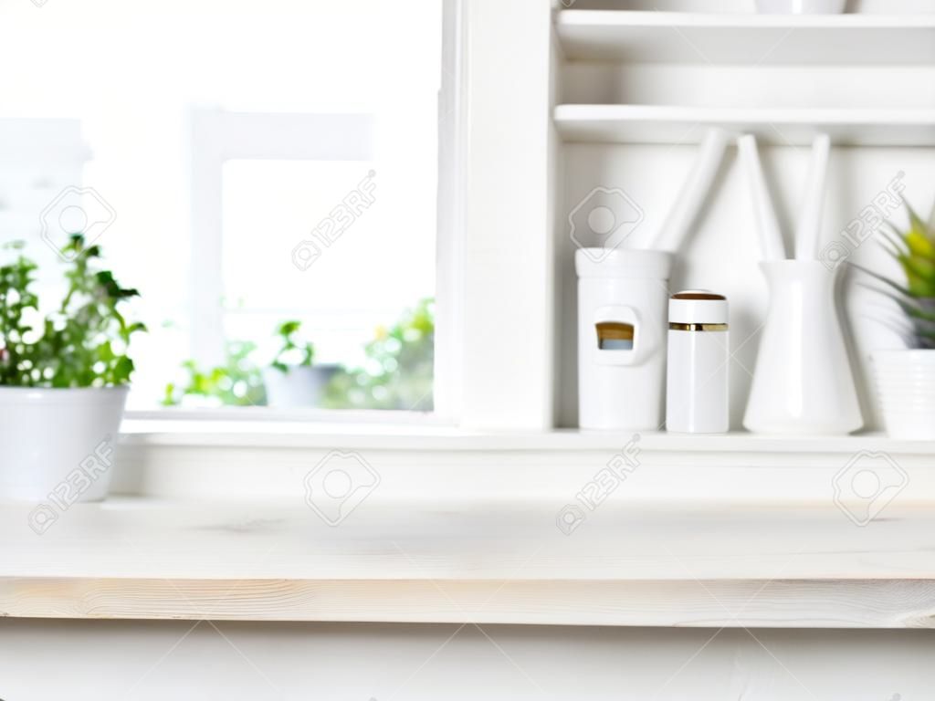 Empty bleached wooden table and kitchen window shelves blurred background