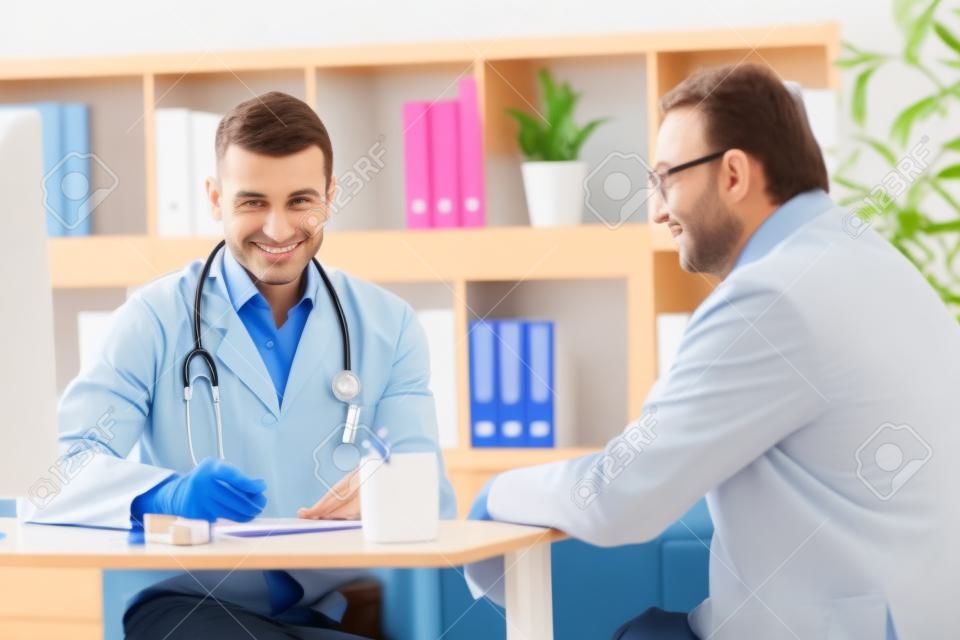 Specjalista lekarz i pacjent uśmiechnięty i rozmawia w biurze