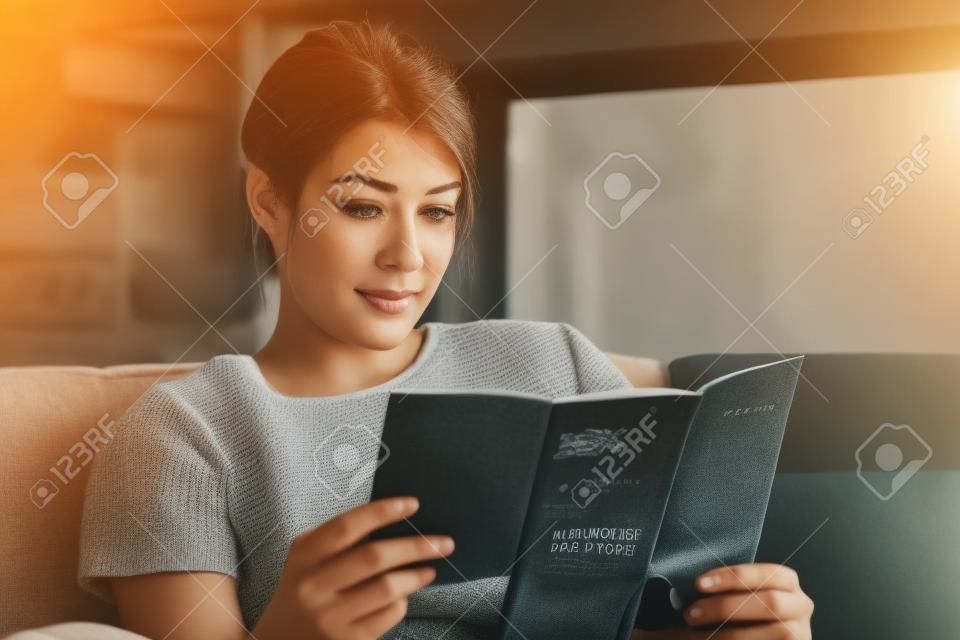 Woman Reading Travel Flye op de bank thuis
