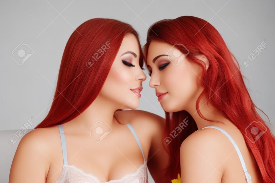 Dos hermosas mujeres jóvenes vestidos de lencería en estrecho contacto