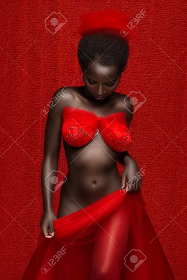 Petite ruandische Frau in rotem Tüll gehüllt