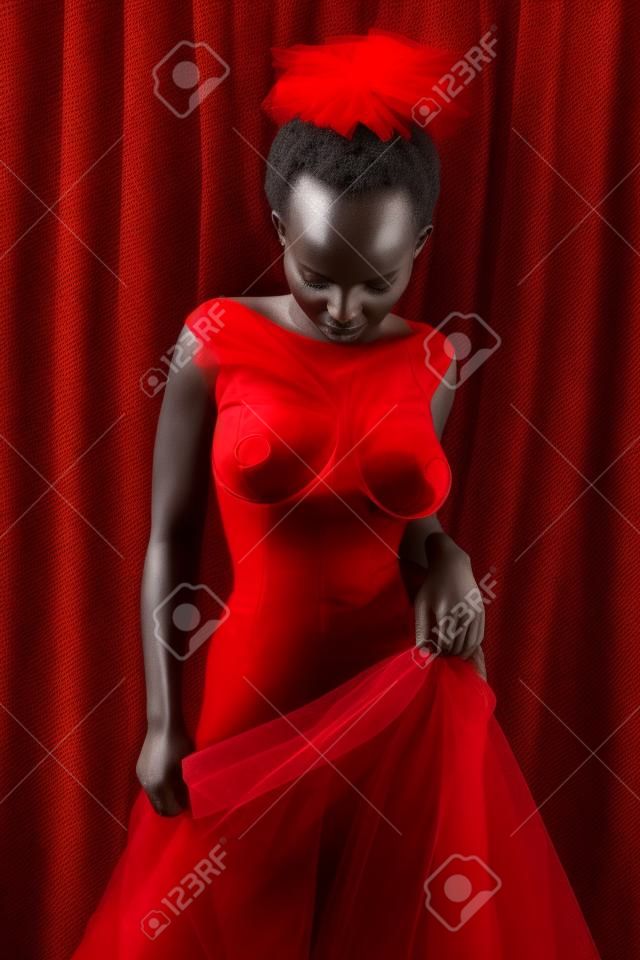 Petite ruandische Frau in rotem Tüll gehüllt