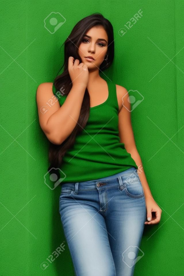 Pretty petite brunette in a green knit top and jeans