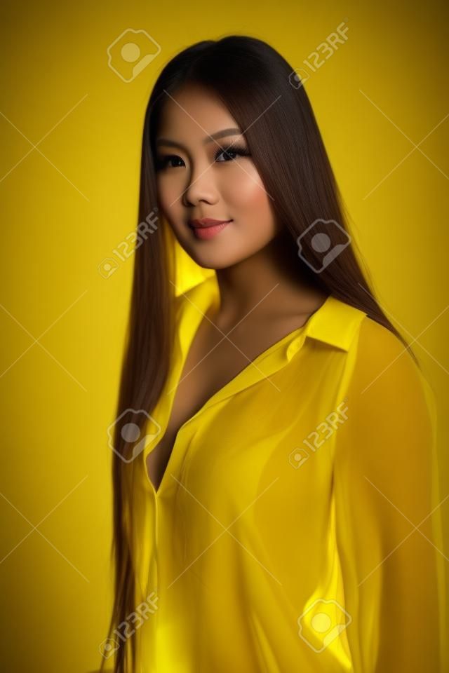 Bella donna filippina minuta in una camicetta gialla trasparente
