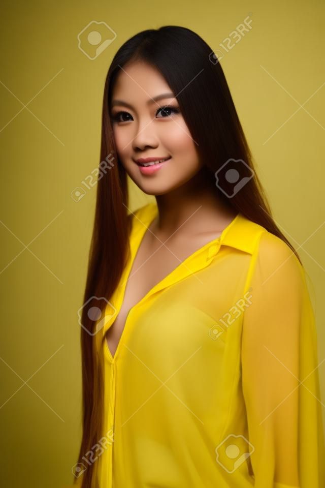 Bella donna filippina minuta in una camicetta gialla trasparente