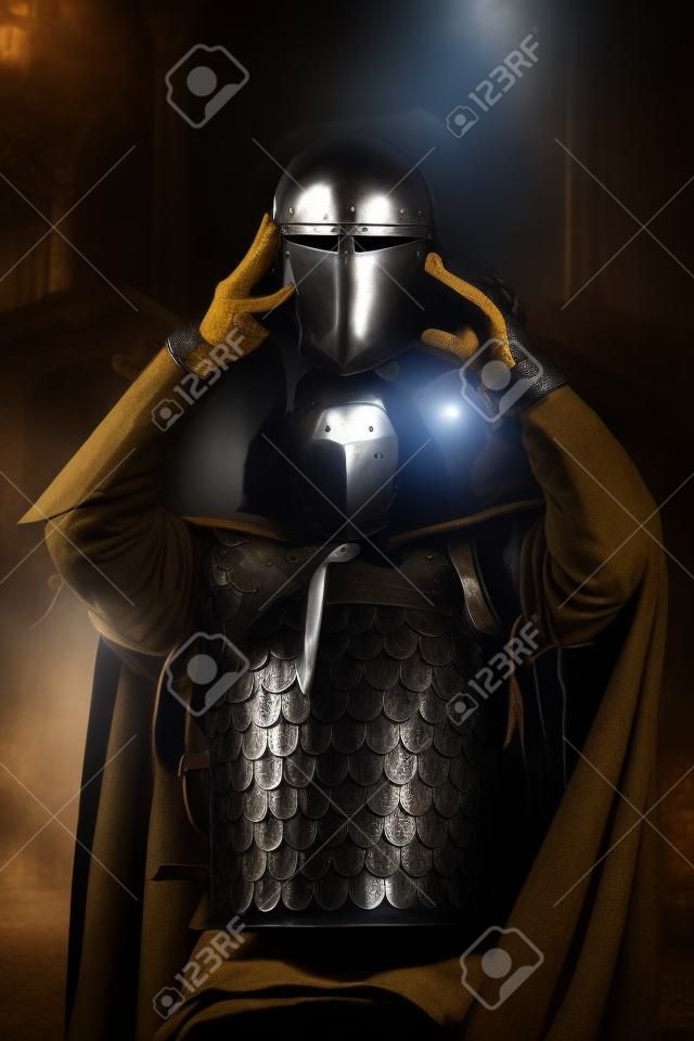 中世の騎士はヘルメットを着用するつもりです。影の肖像画。
