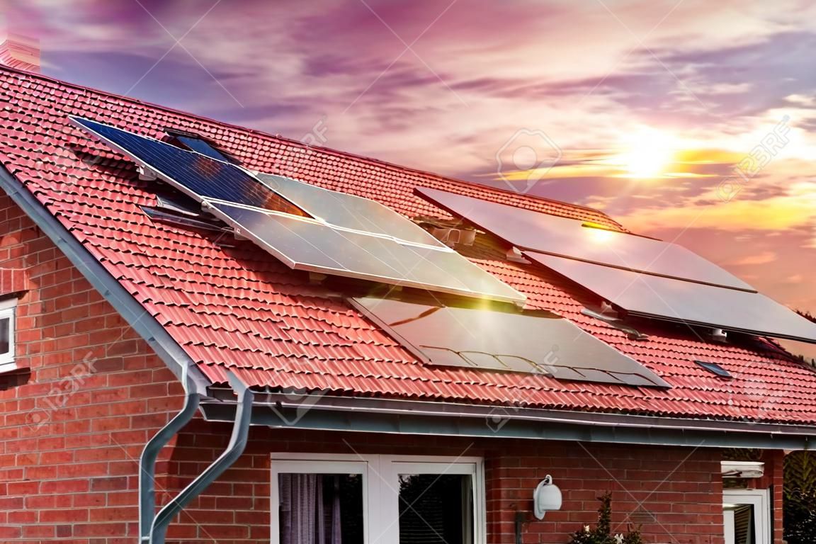 ソーラーパネルの写真のコラージュ、家の赤い屋根の太陽光発電、夕日の美しい空。代替電源。持続可能な資源の概念