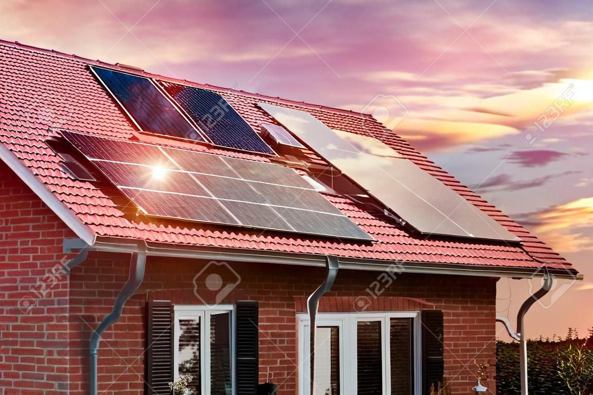 Collage photo de panneaux solaires, photovoltaïques sur le toit rouge d'une maison et d'un beau ciel avec le soleil couchant. Source d'électricité alternative. Concept de ressources durables
