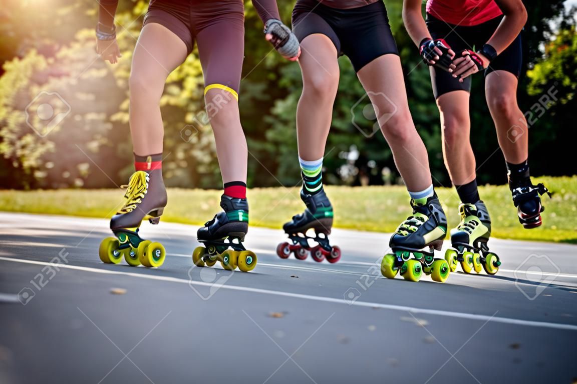 아스팔트 도로의 공원에서 경주하는 인라인 롤러 스케이터