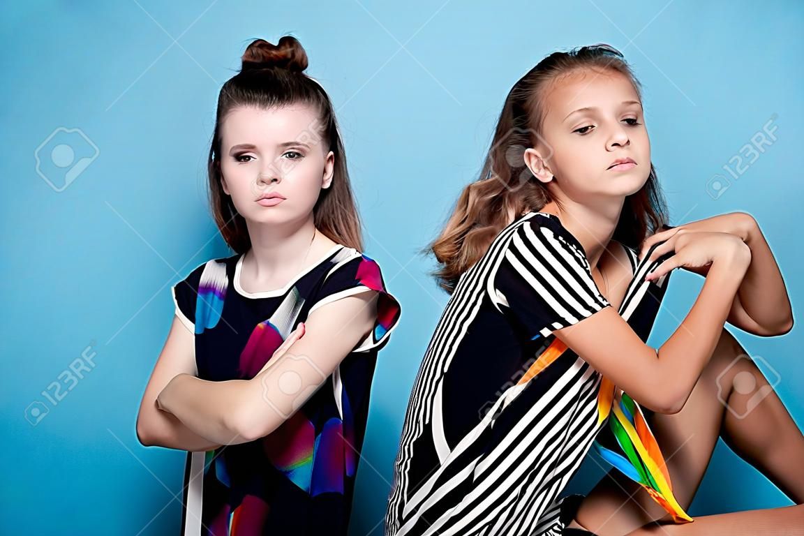 fashion portrait of two girls on a blue background
