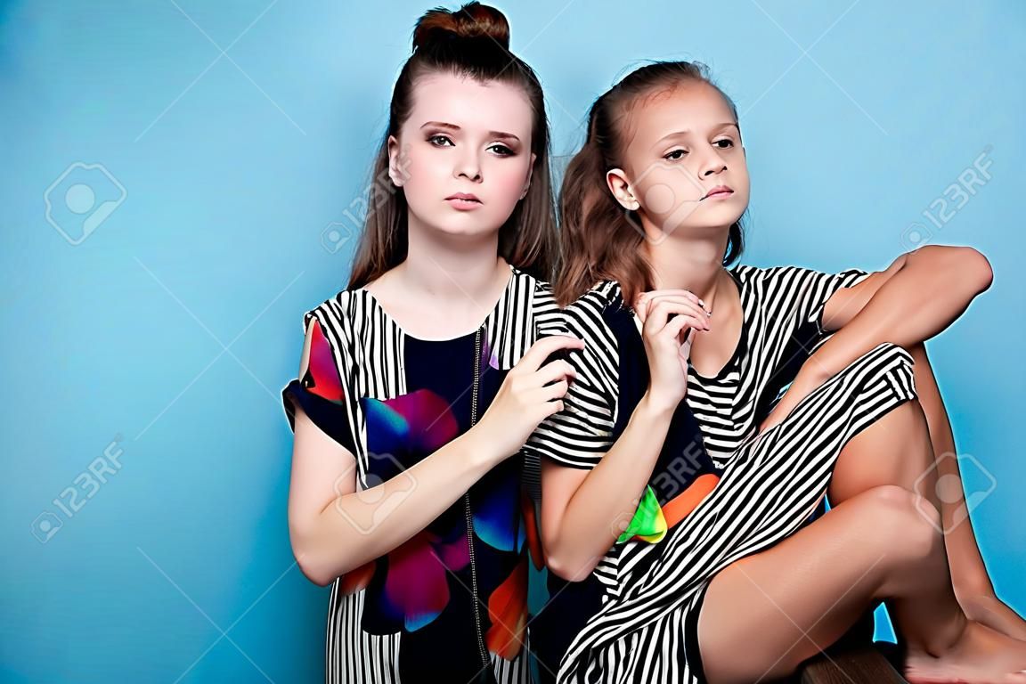 fashion portrait of two girls on a blue background