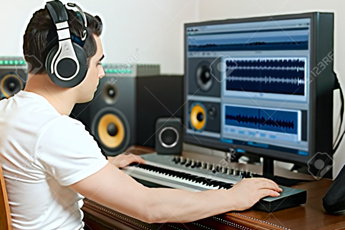 Мужчина звукорежиссер работает в студии звукозаписи.