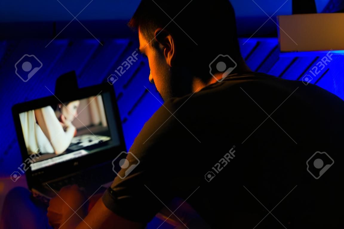 Mann chattet spät in der Nacht mit Webcam-Model.