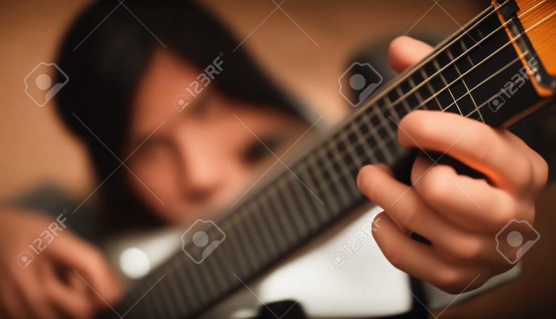 Menina tocando guitarra semi-acústica em casa.