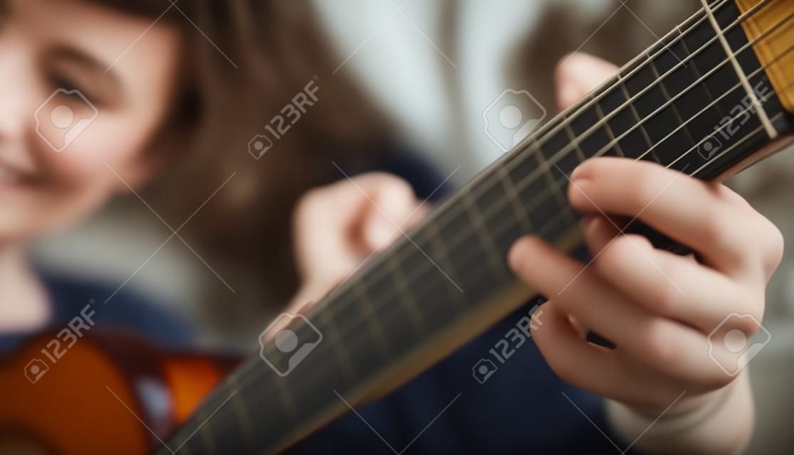 Menina tocando guitarra semi-acústica em casa.