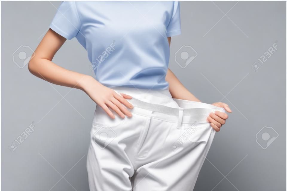 Woman on a weight loss diet large pants measuring a slim figure
