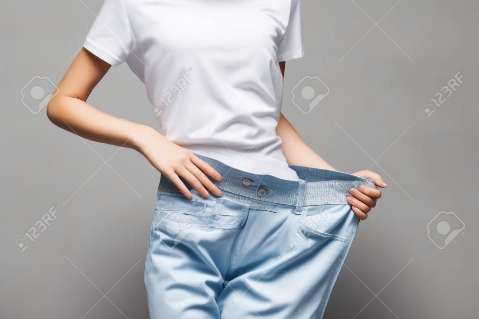 Woman on a weight loss diet large pants measuring a slim figure
