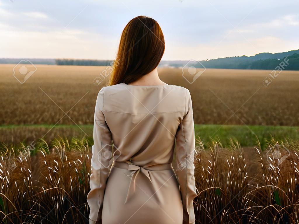 Back view of romantic woman outdoors in the fields
