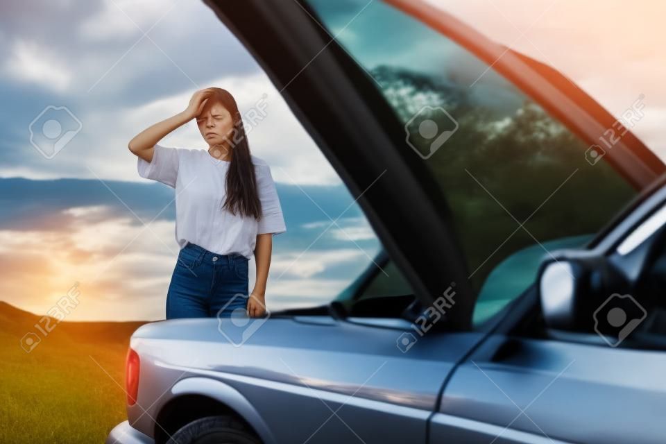 Kobieta smutna i zła z powodu awarii samochodu podczas samotnej podróży i kładzenia rąk na głowie z powodu niezrozumienia problemu z samochodem