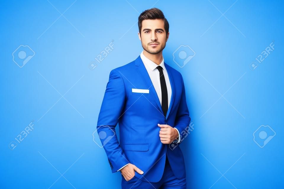 Mężczyzna biznesmen w stylowym garniturze z krawatem marynarki i białą koszulą na niebieskim tle portretu