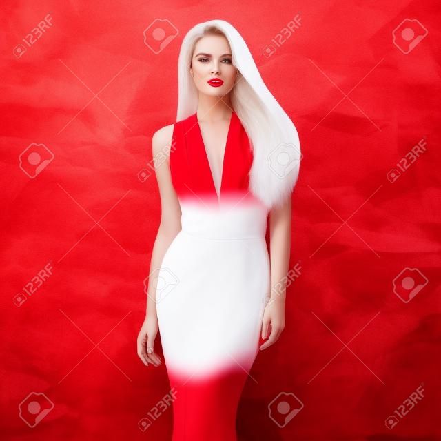 年轻漂亮迷人的女子在优雅优雅的白色晚礼服和红色的鞋子对时尚的红色背景