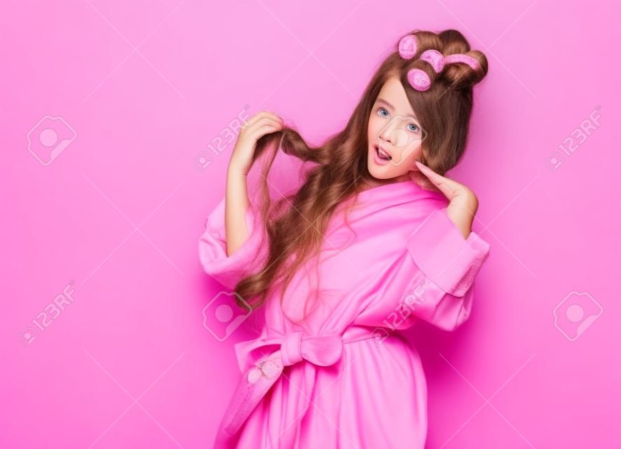 Menina jovem ou adolescente no salão de spa é surpreendido ou assustado com sua condição de estilo de cabelo. Atos como picky insta-model. Conceito de beleza no fundo rosa